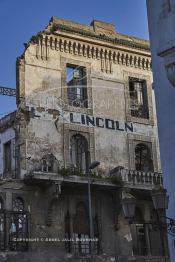 Image du Maroc Professionnelle de  Petit à petit L’hôtel Lincoln située sur le Boulevard Mohammed V à Casablanca quitte ce monde. Construit par des matériaux poreux et sans étanchéité au début du 20e siècle. Déjà en 1989 suite aux accidents qui ont causé des morts et plusieurs blessés, le bâtiment a été vidé avec cessation de toute activités des commerces et cafés. La construction risquait de s’écrouler à tout moment car elle était instable selon le rapport de l’expertise. Suite aux fortes pluies et rafales de vent qui se sont abattues sur Casablanca en Février 2009, une partie de l’édifice s’est effondrée. Maintenant gisant sur le sol et réduite en miettes, la moitié de la façade de ce lieu mythique.  Dix ans après l’écriture de ce texte rien n’a été fait ! Renaîtra-t-il de ses poussières un jour après ces dramatiques chutes mortelle ? Samedi 21 Mars 2009. (Photo / Abdeljalil Bounhar)